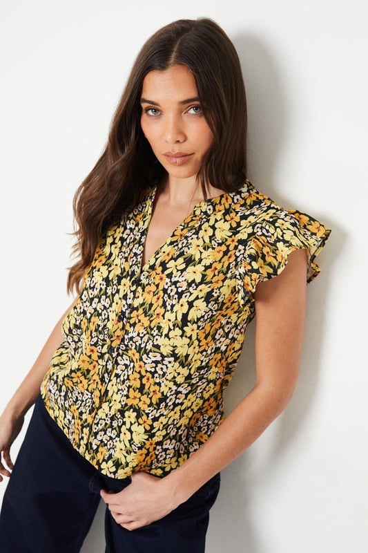 Floral printed woven top with a button-front design
Flattering ruffle trim along the neckline and cap sleeves
Relaxed fit through the body for effortless styling
Lightweight and breathable fabric for warm weather wear
Versatile length that can be tucked or left untucked

This petite floral top from Dorothy Perkins exudes a charming, feminine aesthetic that's perfect for smart casual occasions. The vibrant print and ruffle detailing add a touch of playfulness, while the button-front design lends a polished look. Pair it with tailored trousers or a pencil skirt for a sophisticated brunch ensemble, or dress it down with denim for a more relaxed vibe. Its versatility makes it an ideal choice for baby showers, afternoon teas, or any event where you want to look stylish yet comfortable.