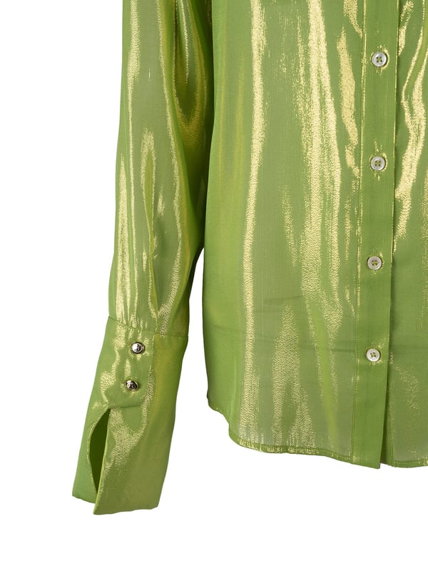 El diseño simple de esta blusa hace que sea extremadamente versátil y adecuada para muchos estilos, desde los diarios hasta los más elegantes, asegurando al mismo tiempo comodidad durante todo el día.

Con un cuello que añade clase y sofisticación, esta blusa se convierte en la elección ideal para reuniones de negocios o salidas nocturnas, combinando elegancia y modernidad.

Abrochada con botones con logotipo, que no solo son prácticos sino que también añaden un sutil toque de lujo, haciendo que cada detalle de esta blusa esté cuidadosamente pensado.

Adornada con un hilo metálico que brilla delicadamente bajo la luz, añadiendo un encanto único a la blusa y haciendo que atraiga las miradas en cualquier situación.

Los puños se abrochan con botones decorativos con el logo de la marca, que constituyen un elegante acento, destacando el cuidado por los detalles y el prestigio de esta blusa excepcional.

Hecha de un tejido de seda transparente de alta calidad, que no solo es agradable al tacto sino que también permite que la piel respire, asegurando comodidad incluso en los días más calurosos.