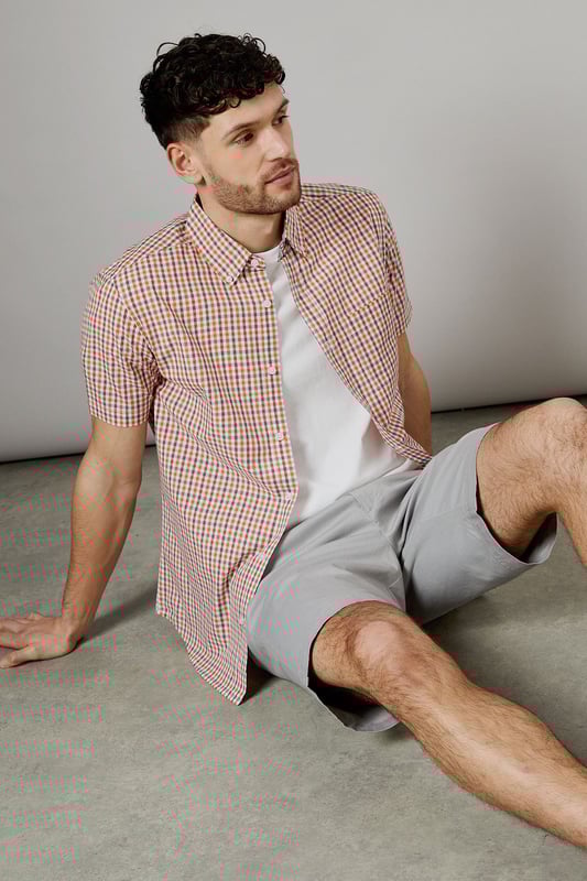 Vibrant check pattern for a stylish summer look
        Short sleeves for optimal comfort in warm weather
        Button-down collar for a smart-casual appearance
        Chest pocket adds a functional touch
        Versatile woven fabric suitable for various occasions
    
    Embrace the essence of laid-back sophistication with this eye-catching Helios check shirt from Maine. The striking pattern adds a dash of personality to your wardrobe, making it an ideal choice for casual outings and relaxed social gatherings. Style it effortlessly with light-coloured chino shorts and white trainers for a fresh summer ensemble. For a more polished look, pair it with tailored trousers and loafers. The short sleeves and breathable cotton fabric ensure you stay cool and comfortable, whether you're enjoying a family barbecue or meeting friends for a leisurely brunch. This versatile shirt transitions seamlessly from day to night, making it a must-have addition to your casual wardrobe. Layer it over a plain white t-shirt for added dimension, or wear it unbuttoned over a vest for a relaxed beach-ready look.