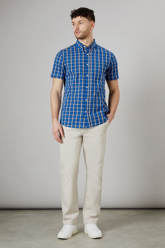 Vibrant check pattern for a bold, eye-catching look
        Short sleeves perfect for warmer weather
        Button-down collar for a smart-casual appearance
        Chest pocket adds a functional touch
        Regular fit allows for comfortable movement
    
    This Maine short sleeve shirt radiates casual charm with its striking check pattern. The bright blue hues create a lively aesthetic that's sure to turn heads. Crafted from pure cotton, it offers breathability and comfort ideal for summer days. Style it with light-coloured chinos and white trainers for a fresh daytime look perfect for weekend brunches or casual gatherings. For a more relaxed vibe, pair it with your favourite denim shorts and sandals for a seaside stroll. The versatile design allows for easy transition from day to night - simply swap your trainers for loafers and you're ready for an evening at the local pub. This shirt is a wardrobe essential that combines style and practicality, making it a go-to choice for various casual occasions throughout the warmer months.