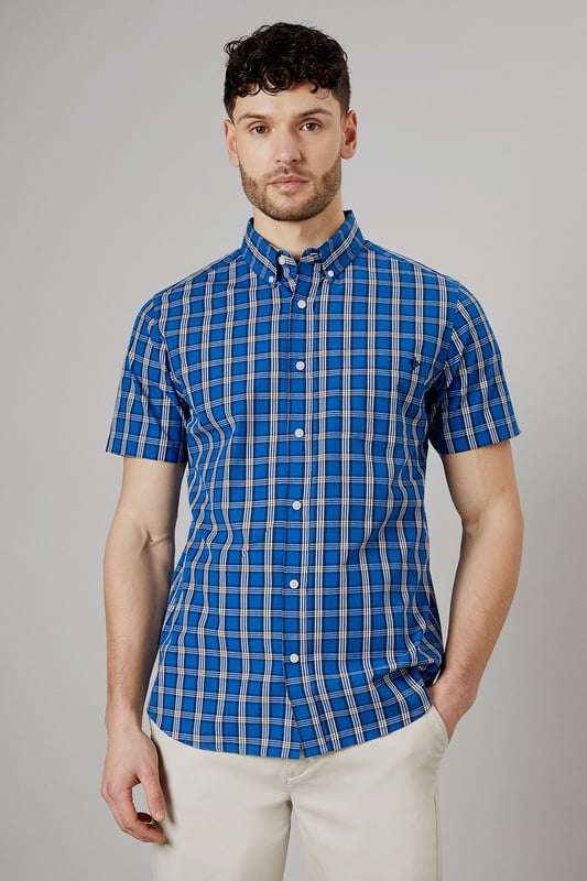Vibrant check pattern for a bold, eye-catching look
        Short sleeves perfect for warmer weather
        Button-down collar for a smart-casual appearance
        Chest pocket adds a functional touch
        Regular fit allows for comfortable movement
    
    This Maine short sleeve shirt radiates casual charm with its striking check pattern. The bright blue hues create a lively aesthetic that's sure to turn heads. Crafted from pure cotton, it offers breathability and comfort ideal for summer days. Style it with light-coloured chinos and white trainers for a fresh daytime look perfect for weekend brunches or casual gatherings. For a more relaxed vibe, pair it with your favourite denim shorts and sandals for a seaside stroll. The versatile design allows for easy transition from day to night - simply swap your trainers for loafers and you're ready for an evening at the local pub. This shirt is a wardrobe essential that combines style and practicality, making it a go-to choice for various casual occasions throughout the warmer months.
