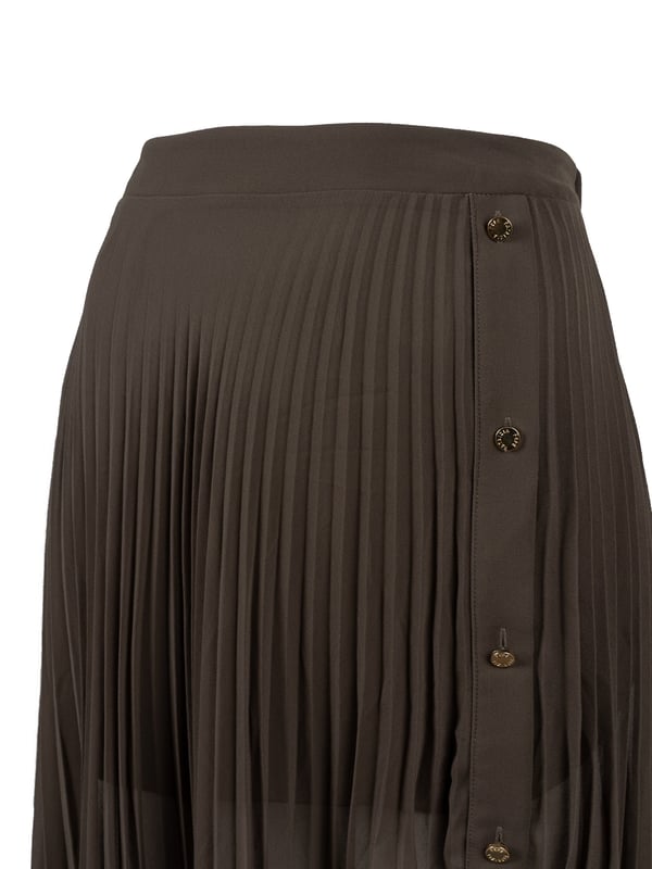 De geplooide, asymmetrische rok is een echte must-have in elke garderobe en combineert moderne stijl met elegantie, perfect voor elke gelegenheid, van casual bijeenkomsten tot avondgebeurtenissen.

Met een elastische tailleband is de rok niet alleen comfortabel om te dragen, maar biedt hij ook een perfecte pasvorm, waardoor hij niet alleen stijlvol maar ook uiterst praktisch is.

Met een korte onderrok die het delicate karakter subtiel benadrukt, staat de rok garant voor discretie en comfort en voegt hij tegelijkertijd charme toe aan elke stap.

Aan de zijkant zijn sierknopen met logo aangebracht, die niet alleen functioneel zijn maar ook dienst doen als mode-element en de rok uniek en geraffineerd maken.

De rok is gemaakt van licht doorschijnende stof van hoge kwaliteit, is licht en luchtig, ideaal voor warme dagen en laat je benen subtiel zien.

De rok is gemaakt in Italië, wat de hoogste kwaliteit van afwerking en aandacht voor detail garandeert, en is een uitstekende keuze voor mensen die stijl en elegantie in elke situatie waarderen.