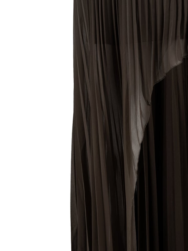 De geplooide, asymmetrische rok is een echte must-have in elke garderobe en combineert moderne stijl met elegantie, perfect voor elke gelegenheid, van casual bijeenkomsten tot avondgebeurtenissen.

Met een elastische tailleband is de rok niet alleen comfortabel om te dragen, maar biedt hij ook een perfecte pasvorm, waardoor hij niet alleen stijlvol maar ook uiterst praktisch is.

Met een korte onderrok die het delicate karakter subtiel benadrukt, staat de rok garant voor discretie en comfort en voegt hij tegelijkertijd charme toe aan elke stap.

Aan de zijkant zijn sierknopen met logo aangebracht, die niet alleen functioneel zijn maar ook dienst doen als mode-element en de rok uniek en geraffineerd maken.

De rok is gemaakt van licht doorschijnende stof van hoge kwaliteit, is licht en luchtig, ideaal voor warme dagen en laat je benen subtiel zien.

De rok is gemaakt in Italië, wat de hoogste kwaliteit van afwerking en aandacht voor detail garandeert, en is een uitstekende keuze voor mensen die stijl en elegantie in elke situatie waarderen.