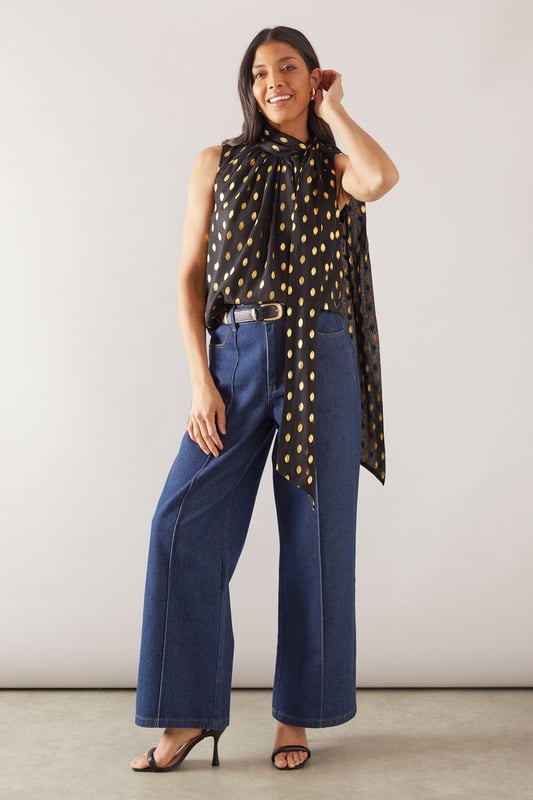Sleeveless design for effortless warm-weather style
        High neck with elegant gathered detail
        Striking polka dot pattern throughout
        Flowing fabric for a graceful silhouette
        Versatile length suitable for various styling options
    
    This Wallis broderie collarless shirt radiates sophistication with its eye-catching polka dot pattern and refined high neck design. The gathered detail at the neckline adds a touch of elegance, while the sleeveless cut ensures comfort during warmer days. Perfect for daytime events, this versatile piece can be styled effortlessly for various casual occasions. Pair it with wide-leg trousers and a statement belt for a chic family gathering look, or team it with your favourite denim for a stylish brunch ensemble. The flowing fabric drapes beautifully, creating a flattering silhouette that's both comfortable and fashionable. Whether you're heading to a casual meetup with friends or a relaxed day out shopping, this shirt offers the perfect blend of comfort and style. Accessorise with delicate earrings and comfortable flats to complete your polished yet laid-back look.