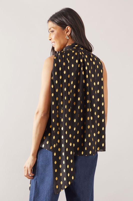 Sleeveless design for effortless warm-weather style
        High neck with elegant gathered detail
        Striking polka dot pattern throughout
        Flowing fabric for a graceful silhouette
        Versatile length suitable for various styling options
    
    This Wallis broderie collarless shirt radiates sophistication with its eye-catching polka dot pattern and refined high neck design. The gathered detail at the neckline adds a touch of elegance, while the sleeveless cut ensures comfort during warmer days. Perfect for daytime events, this versatile piece can be styled effortlessly for various casual occasions. Pair it with wide-leg trousers and a statement belt for a chic family gathering look, or team it with your favourite denim for a stylish brunch ensemble. The flowing fabric drapes beautifully, creating a flattering silhouette that's both comfortable and fashionable. Whether you're heading to a casual meetup with friends or a relaxed day out shopping, this shirt offers the perfect blend of comfort and style. Accessorise with delicate earrings and comfortable flats to complete your polished yet laid-back look.