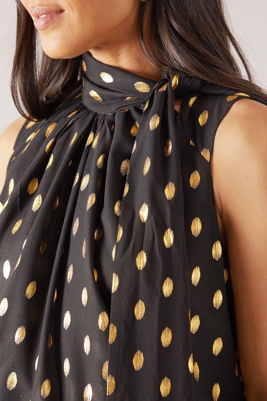 Sleeveless design for effortless warm-weather style
        High neck with elegant gathered detail
        Striking polka dot pattern throughout
        Flowing fabric for a graceful silhouette
        Versatile length suitable for various styling options
    
    This Wallis broderie collarless shirt radiates sophistication with its eye-catching polka dot pattern and refined high neck design. The gathered detail at the neckline adds a touch of elegance, while the sleeveless cut ensures comfort during warmer days. Perfect for daytime events, this versatile piece can be styled effortlessly for various casual occasions. Pair it with wide-leg trousers and a statement belt for a chic family gathering look, or team it with your favourite denim for a stylish brunch ensemble. The flowing fabric drapes beautifully, creating a flattering silhouette that's both comfortable and fashionable. Whether you're heading to a casual meetup with friends or a relaxed day out shopping, this shirt offers the perfect blend of comfort and style. Accessorise with delicate earrings and comfortable flats to complete your polished yet laid-back look.