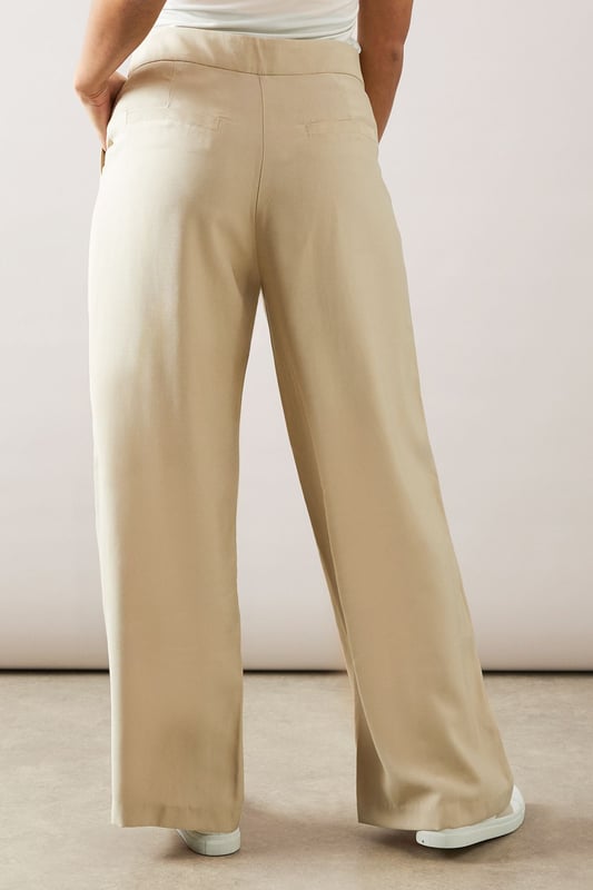 Elegant straight leg design for a timeless silhouette
        Pleated front detail adds sophistication and structure
        Wide waistband for a comfortable and flattering fit
        Side pockets for practicality and style
        Versatile length suitable for various shoe choices
    
    These straight leg pleated trousers from Wallis are the epitome of effortless chic. Perfect for the woman who values both comfort and style, they offer a sophisticated look for various daytime occasions. The pleated front adds a touch of refinement, while the straight leg cut ensures a flattering fit for all body types. Style these trousers with a crisp white blouse and ballet flats for a polished look at family gatherings, or pair with a soft knit jumper and loafers for a smart-casual ensemble ideal for lunch with friends. The versatile design makes these trousers a wardrobe staple, easily transitioning from a day at the office to weekend brunches. Accessorise with a statement necklace and a structured tote to complete your look with Wallis' signature glamour.