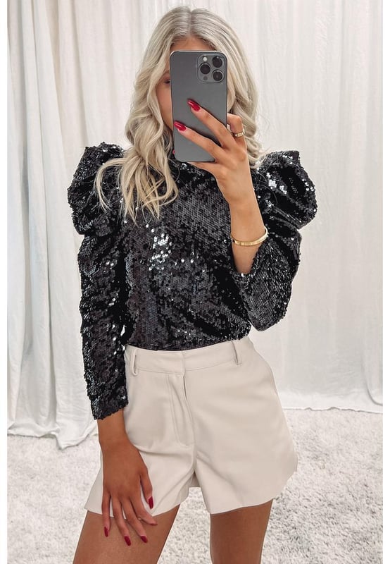 Black Sequin Mock Neck Bubble Sleeve Top
  Sleek black color with sequin embellishments
  Contemporary mock neck design
  Playful bubble sleeves
  Made from high
  quality materials
  Suitable for both men and women
  Versatile piece for various occasions