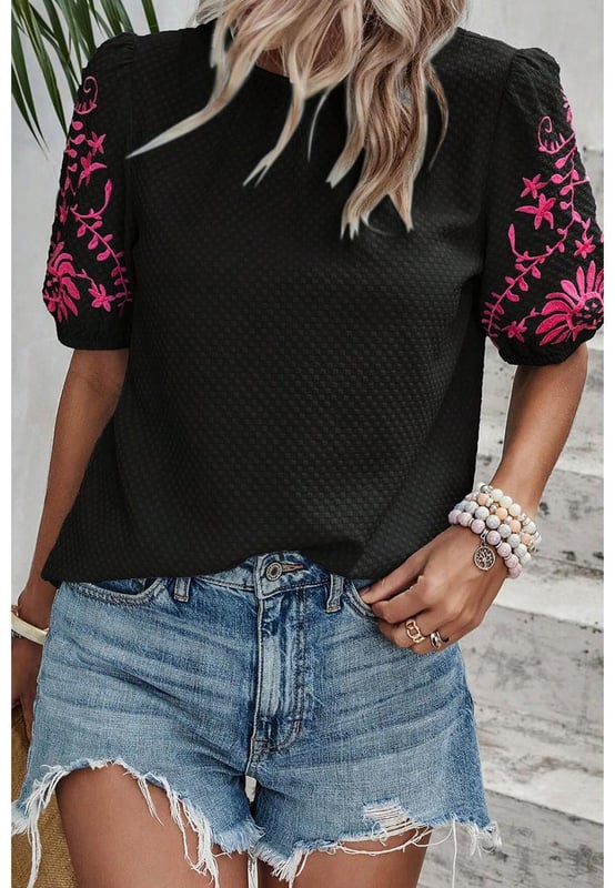 Camiseta de manga abullonada texturizada con bordado floral en negro  
Presenta un intrincado bordado floral en las mangas  
Adorables mangas abullonadas  
El tejido texturizado añade un toque de sofisticación  
Combínala con diversas prendas inferiores para looks versátiles  
Disponible en tallas unisex  
Material: 95% Poliéster 5% Elastano