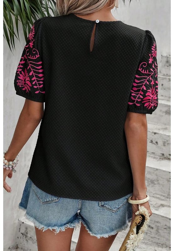 Camiseta de manga abullonada texturizada con bordado floral en negro  
Presenta un intrincado bordado floral en las mangas  
Adorables mangas abullonadas  
El tejido texturizado añade un toque de sofisticación  
Combínala con diversas prendas inferiores para looks versátiles  
Disponible en tallas unisex  
Material: 95% Poliéster 5% Elastano
