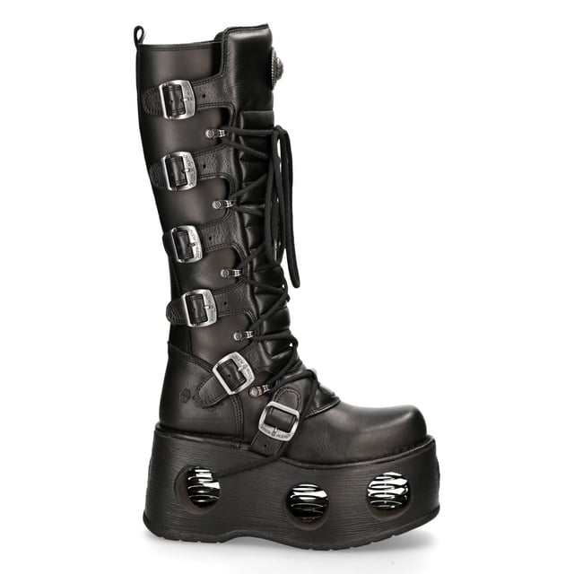 New Rock M-272-S2 Neptuno Metallic Knee High Black Leather Gothic Boots The New Rock M-272-S2 Neptuno boots from the Metallic Collection redefine gothic and punk-rock style with their towering design. Crafted from premium black cow leather with a pigskin interior, they offer durability and comfort. The extra-high 38 cm shaft, bold buckles, and signature logo on the tongue add to their fierce aesthetic. Featuring an impressive 11 cm platform heel with distinctive cutouts, these boots are a statement piece for those who embrace alternative fashion.
Key Features:
Material: Outer - Cow Leather | Inner - Pigskin
Heel Height: 11 cm | Platform Height: 9 cm
Sole Material: TPU | Fixing System: Glued
Fastening: Laces & Buckles
Shaft Height: 38 cm
Style: Gothic, Heavy, Punk, Rock
Unisex Design: Suitable for all gernders
Distinctive Details: Buckled shaft, perforated platform, logo on tongue