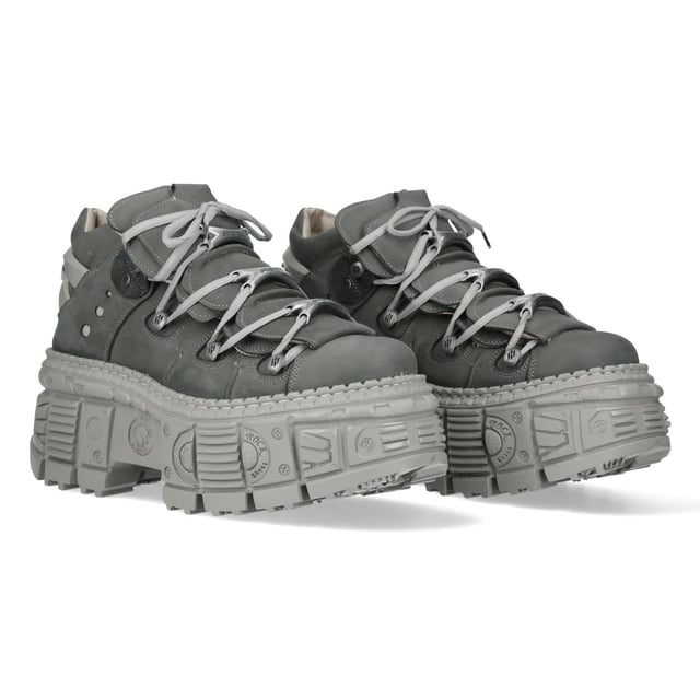 Botines góticos urbanos de cuero gris New Rock M-106WALL-C63 Los botines New Rock M-106WALL-C63 de la Colección Wall combinan un estilo urbano con una estética rockera contundente. Confeccionados en piel de vacuno gris de alta calidad con un interior de suave piel de becerro, ofrecen durabilidad y comodidad. Su audaz tacón de 7 cm y plataforma de 9 cm crean una silueta impactante, mientras que el diseño con cordones realza su estilo robusto y urbano. Con una suela pegada y cosida para mayor resistencia, estos botines unisex son la fusión perfecta de estilo y resistencia. Características principales: Material: Exterior: Piel de vacuno | Interior: Piel de becerro | Altura del tacón: 7 cm | Altura de la plataforma: 9 cm | Material de la suela: PU-ULTRA | Sistema de fijación: Pegado y cosido | Cierre: Cordones (cordón) | Altura de la caña: 12 cm | Estilo: Urbano, Rockero, Rockero | Diseño unisex: Apto para hombre y mujer | Color distintivo: Gris para una estética atrevida y moderna