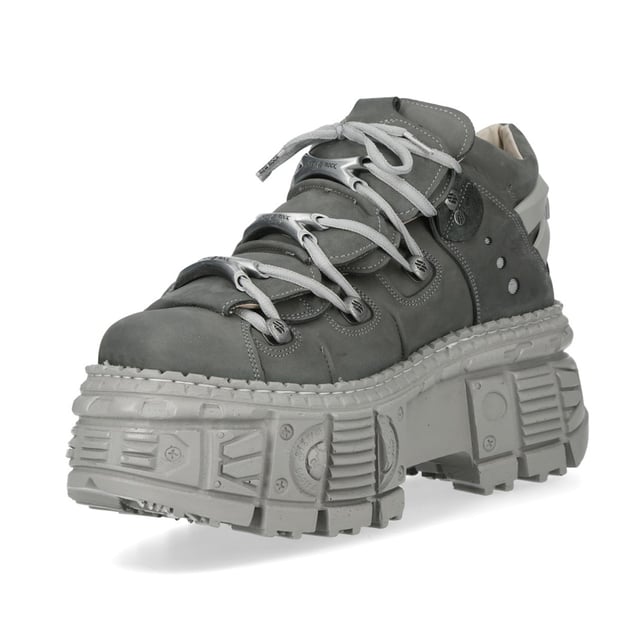 Botines góticos urbanos de cuero gris New Rock M-106WALL-C63 Los botines New Rock M-106WALL-C63 de la Colección Wall combinan un estilo urbano con una estética rockera contundente. Confeccionados en piel de vacuno gris de alta calidad con un interior de suave piel de becerro, ofrecen durabilidad y comodidad. Su audaz tacón de 7 cm y plataforma de 9 cm crean una silueta impactante, mientras que el diseño con cordones realza su estilo robusto y urbano. Con una suela pegada y cosida para mayor resistencia, estos botines unisex son la fusión perfecta de estilo y resistencia. Características principales: Material: Exterior: Piel de vacuno | Interior: Piel de becerro | Altura del tacón: 7 cm | Altura de la plataforma: 9 cm | Material de la suela: PU-ULTRA | Sistema de fijación: Pegado y cosido | Cierre: Cordones (cordón) | Altura de la caña: 12 cm | Estilo: Urbano, Rockero, Rockero | Diseño unisex: Apto para hombre y mujer | Color distintivo: Gris para una estética atrevida y moderna