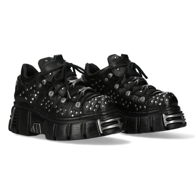 Botines de plataforma góticos de cuero negro M-120NR-C1 de New Rock Los botines New Rock M-120NR-C1 de la Colección Metallic fusionan la estética gótica, punk y rockera con un toque inconfundible. Fabricados en piel de vacuno negra de alta calidad con interior sintético, estos botines ofrecen durabilidad y un look atrevido. Con un llamativo tacón de plataforma de 6 cm, ofrecen una postura imponente y elevada. Su diseño con cordones garantiza un ajuste seguro, lo que los convierte en un imprescindible para quienes adoptan la moda alternativa con una actitud rebelde. Características principales: Material: Exterior: Piel de vacuno | Interior: Sintético | Altura del tacón: 6 cm | Altura de la plataforma: 6 cm | Material de la suela: PU-ULTRA | Cierre: Cordones | Altura de la caña: 10 cm | Estilo: Gótico, Heavy, Punk, Rock | Diseño unisex: Apto para hombre y mujer.