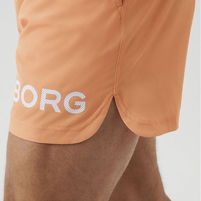 Björn Borg - Men’s Technical Training Shorts: Stay confident when training in these sleek Men's Technical Shorter-Length Training Shorts by Björn Borg. They are great for everyday use and any type of training you might be doing. The Björn Borg Short Shorts are sleek and technical training shorts made from 92% recycled polyester stretch quality fabric with jersey fabric between the legs. They are constructed with a breathable material that dries quickly. They are regular fit with a short leg length, and feature a branded elastic around the waist for easy adjustment and support. With front pockets and slits on the side for extra movement. The shorts feature an iconic Borg logo on the side. The recycled material makes them perfect for hot weather, keeping you cool while you're sweating. It’s not only high quality but Eco Friendly as well, so you can feel good about what you're wearing and doing for the environment!. These shorts are made from: 92% Polyester (Recycled), 8% Elastane and come in 4 sizes: Small, Medium, Large & X-Large. They come in 2 colours: Black or Cadmium Orange and are Machine Washable. Extra Product Details: Björn Borg Men’s Shorts Ideal For Everyday Great For Workouts & Training Breathable Material Jersey Fabric Between Legs Branded Elasticated Waist Iconic Borg Logo On Side Quick Drying Comes In Black or Orange 92% Recycled Polyester Eco Friendly