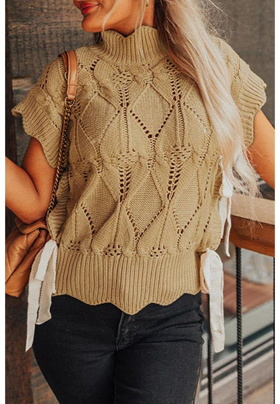 Color beige francés claro  
Diseño de punto ahuecado  
Terminación con volantes en el escote, mangas y dobladillo  
Escote alto  
Mangas cortas con volantes  
Laterales con detalles en volantes y acentos de lazo  
Silhouette relajada pero favorecedora  
Combina bien con pantalones, faldas y jeans  
Alta calidad y estilo chic  
Disponible en múltiples tamaños  
Material: 60% algodón, 40% acrílico