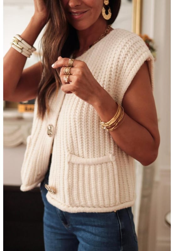 White solid textured knit sweater vest
  Buttoned front closure for a classic look
  Sleeveless design for easy layering
  Side pockets for practical functionality
Material: 100% Acrylic