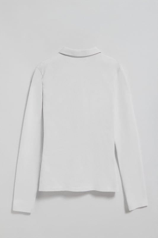 Langärmliges Damen-Poloshirt im Slim Fit aus Baumwollpiqué und Elasthan. Unser Poloshirt Pryanka hat eine frontale Knopfleiste mit fünf Perlmuttknöpfen, die farblich auf das Shirt abgestimmt sind. Kragen und Ärmelbündchen aus Baumwollpiqué für einen femininen, modernen Look. Kleine Öffnungen an den Enden der seitlichen Nähte. Rigby Go Stickerei auf der Brust und personalisierte Nahtbänder.