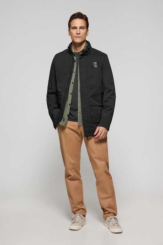 Der leichte Herrenparka Chelsea ist auf Funktionalität und Stil ausgelegt und kombiniert modernes Design mit klassischen Details. Die verdeckte Kapuze am Kragen sorgt für Vielseitigkeit und bietet bei Bedarf Schutz. Er verfügt über zwei aufgesetzte Taschen und eine verdeckte Brusttasche mit Reißverschluss. Der Hauptreißverschluss wird von einer Knopfleiste aus dem Hauptgewebe abgedeckt, die mit Druckknöpfen geschlossen wird und zusätzlichen Schutz vor Wind bietet. An der Innenseite befinden sich zwei Stopper an der Taille, mit denen Sie das Kleidungsstück nach Ihren Wünschen anpassen können. Details wie Zipper, Gummizüge und Stopper mit Logo sowie ein gummierter Aufnäher aus Twill mit dem Polo Club Logo auf der Brust verleihen dem Kleidungsstück eine exklusive und persönliche Note. Ideal für den modernen Mann, der ein leichtes, funktionelles Kleidungsstück mit einem Hauch von Raffinesse sucht.