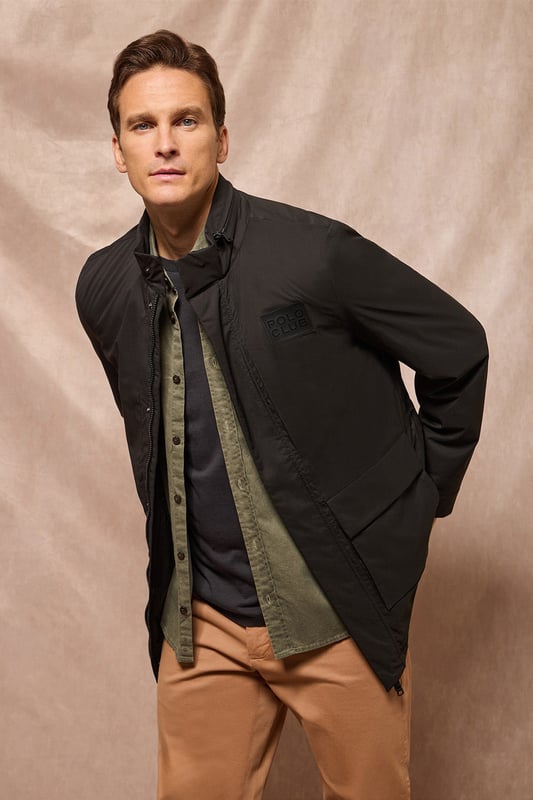 Der leichte Herrenparka Chelsea ist auf Funktionalität und Stil ausgelegt und kombiniert modernes Design mit klassischen Details. Die verdeckte Kapuze am Kragen sorgt für Vielseitigkeit und bietet bei Bedarf Schutz. Er verfügt über zwei aufgesetzte Taschen und eine verdeckte Brusttasche mit Reißverschluss. Der Hauptreißverschluss wird von einer Knopfleiste aus dem Hauptgewebe abgedeckt, die mit Druckknöpfen geschlossen wird und zusätzlichen Schutz vor Wind bietet. An der Innenseite befinden sich zwei Stopper an der Taille, mit denen Sie das Kleidungsstück nach Ihren Wünschen anpassen können. Details wie Zipper, Gummizüge und Stopper mit Logo sowie ein gummierter Aufnäher aus Twill mit dem Polo Club Logo auf der Brust verleihen dem Kleidungsstück eine exklusive und persönliche Note. Ideal für den modernen Mann, der ein leichtes, funktionelles Kleidungsstück mit einem Hauch von Raffinesse sucht.