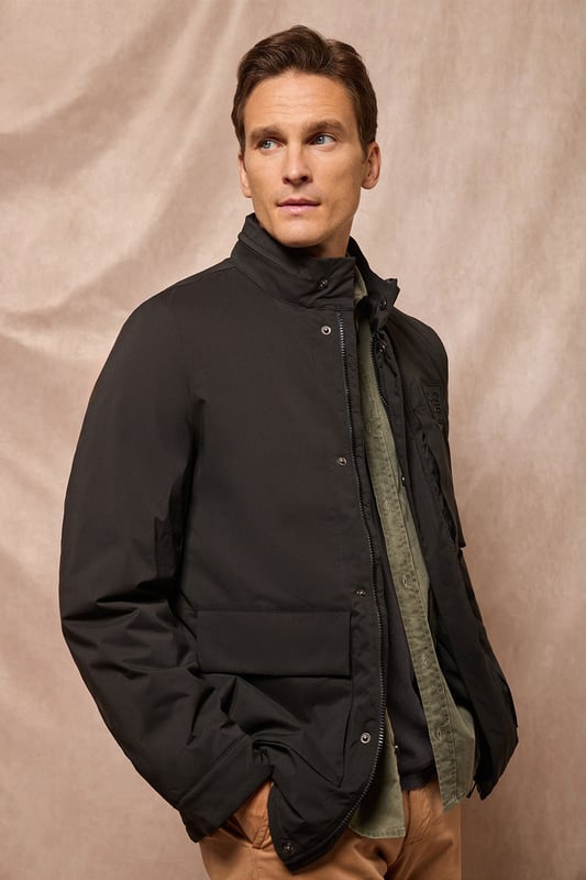 Der leichte Herrenparka Chelsea ist auf Funktionalität und Stil ausgelegt und kombiniert modernes Design mit klassischen Details. Die verdeckte Kapuze am Kragen sorgt für Vielseitigkeit und bietet bei Bedarf Schutz. Er verfügt über zwei aufgesetzte Taschen und eine verdeckte Brusttasche mit Reißverschluss. Der Hauptreißverschluss wird von einer Knopfleiste aus dem Hauptgewebe abgedeckt, die mit Druckknöpfen geschlossen wird und zusätzlichen Schutz vor Wind bietet. An der Innenseite befinden sich zwei Stopper an der Taille, mit denen Sie das Kleidungsstück nach Ihren Wünschen anpassen können. Details wie Zipper, Gummizüge und Stopper mit Logo sowie ein gummierter Aufnäher aus Twill mit dem Polo Club Logo auf der Brust verleihen dem Kleidungsstück eine exklusive und persönliche Note. Ideal für den modernen Mann, der ein leichtes, funktionelles Kleidungsstück mit einem Hauch von Raffinesse sucht.