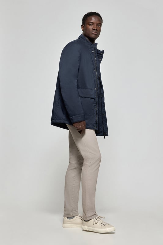 Der leichte Herrenparka Chelsea ist auf Funktionalität und Stil ausgelegt und kombiniert modernes Design mit klassischen Details. Die verdeckte Kapuze am Kragen sorgt für Vielseitigkeit und bietet bei Bedarf Schutz. Er verfügt über zwei aufgesetzte Taschen und eine verdeckte Brusttasche mit Reißverschluss. Der Hauptreißverschluss wird von einer Knopfleiste aus dem Hauptgewebe abgedeckt, die mit Druckknöpfen geschlossen wird und zusätzlichen Schutz vor Wind bietet. An der Innenseite befinden sich zwei Stopper an der Taille, mit denen Sie das Kleidungsstück nach Ihren Wünschen anpassen können. Details wie Zipper, Gummizüge und Stopper mit Logo sowie ein gummierter Aufnäher aus Twill mit dem Polo Club Logo auf der Brust verleihen dem Kleidungsstück eine exklusive und persönliche Note. Ideal für den modernen Mann, der ein leichtes, funktionelles Kleidungsstück mit einem Hauch von Raffinesse sucht.