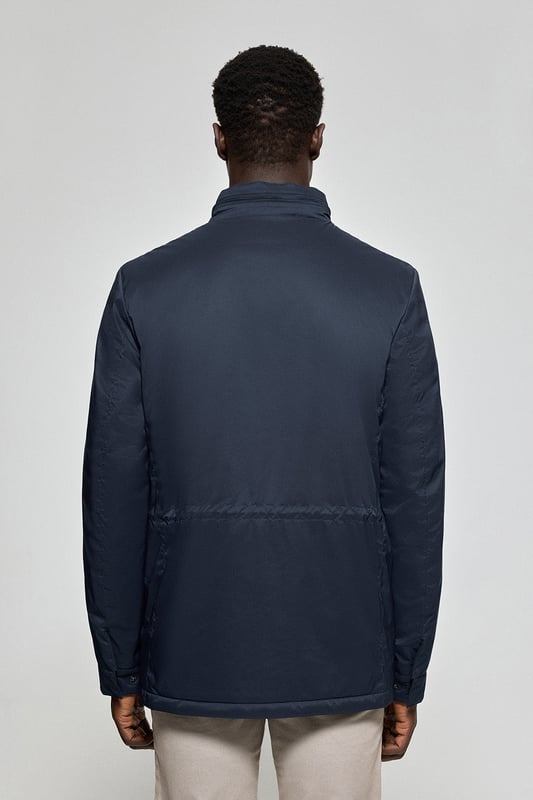 Der leichte Herrenparka Chelsea ist auf Funktionalität und Stil ausgelegt und kombiniert modernes Design mit klassischen Details. Die verdeckte Kapuze am Kragen sorgt für Vielseitigkeit und bietet bei Bedarf Schutz. Er verfügt über zwei aufgesetzte Taschen und eine verdeckte Brusttasche mit Reißverschluss. Der Hauptreißverschluss wird von einer Knopfleiste aus dem Hauptgewebe abgedeckt, die mit Druckknöpfen geschlossen wird und zusätzlichen Schutz vor Wind bietet. An der Innenseite befinden sich zwei Stopper an der Taille, mit denen Sie das Kleidungsstück nach Ihren Wünschen anpassen können. Details wie Zipper, Gummizüge und Stopper mit Logo sowie ein gummierter Aufnäher aus Twill mit dem Polo Club Logo auf der Brust verleihen dem Kleidungsstück eine exklusive und persönliche Note. Ideal für den modernen Mann, der ein leichtes, funktionelles Kleidungsstück mit einem Hauch von Raffinesse sucht.