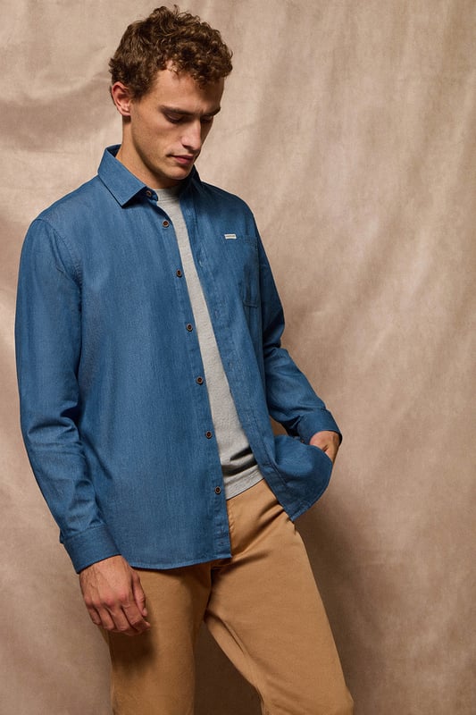 Dieses Denimhemd ist Teil unserer Denim Kollektion. Mit seinem Chambray-Denim-Stoff ist es ein ideales Basic für den Kleiderschrank. Es hat einen französischen Kragen, eine normale Passform und eine Brusttasche mit dem unverwechselbaren Polo Club Etikett. Knopfverschluss mit Logoknöpfen aus Holz, wobei der letzte Knopf waagerecht genäht ist. Die Innenseite des Kragens und der Manschetten sind mit einem kontrastierenden, bedruckten Stoff und farblich abgestimmten Fischgrätennähten abgesetzt. Die Details an den Seiten und die Hängelasche an der Passe aus demselben Stoff vervollständigen dieses einzigartige Kleidungsstück.