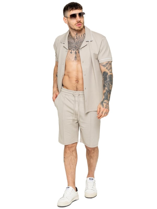 The Enzo Men's Piping Shirt & Shorts Tracksuit offers a stylish and comfortable look. The button-up shirt features a revere collar and white piping details on the collar and sleeves for a refined touch. Made from stretch fabric, it provides flexibility and a sleek fit. Paired with matching stretch shorts, this set ensures comfort and functionality with an elastic waistband, adjustable drawstring, and multiple pockets. Perfect for casual outings or lounging in style. (650&619)