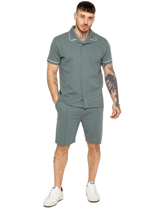 The Enzo Men's Piping Shirt & Shorts Tracksuit offers a stylish and comfortable look. The button-up shirt features a revere collar and white piping details on the collar and sleeves for a refined touch. Made from stretch fabric, it provides flexibility and a sleek fit. Paired with matching stretch shorts, this set ensures comfort and functionality with an elastic waistband, adjustable drawstring, and multiple pockets. Perfect for casual outings or lounging in style. (650&619)