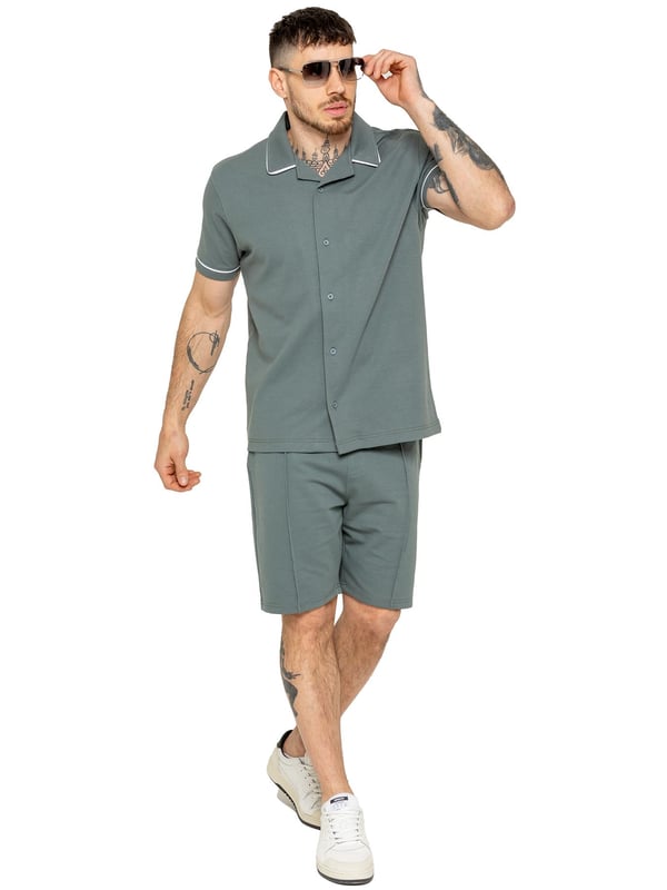 The Enzo Men's Piping Shirt & Shorts Tracksuit offers a stylish and comfortable look. The button-up shirt features a revere collar and white piping details on the collar and sleeves for a refined touch. Made from stretch fabric, it provides flexibility and a sleek fit. Paired with matching stretch shorts, this set ensures comfort and functionality with an elastic waistband, adjustable drawstring, and multiple pockets. Perfect for casual outings or lounging in style. (650&619)