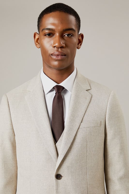 Slim fit design for a modern, tailored silhouette
        Notched lapels and two-button front closure
        Flap pockets and welt breast pocket for classic styling
        Semi-plain fabric adds subtle texture and interest
        Versatile light hue suitable for various occasions
    
    This Burton slim fit suit jacket offers a contemporary take on timeless sophistication. The semi-plain fabric adds a touch of refinement, making it an ideal choice for the discerning gentleman who appreciates classic style with a modern edge. Perfect for smart casual events or more formal occasions, this jacket can be effortlessly dressed up or down. Pair it with matching trousers and a crisp white shirt for a complete suit ensemble, or team it with dark denim and a polo shirt for a more relaxed look. The versatile hue allows for easy coordination with a range of accessories, from patterned ties to pocket squares. Whether you're heading to the office, attending a wedding, or enjoying a night out at the pub, this jacket will ensure you look polished and put-together. Its slim fit silhouette flatters the body while allowing comfortable movement, making it an excellent choice for the active man who values both style and functionality.