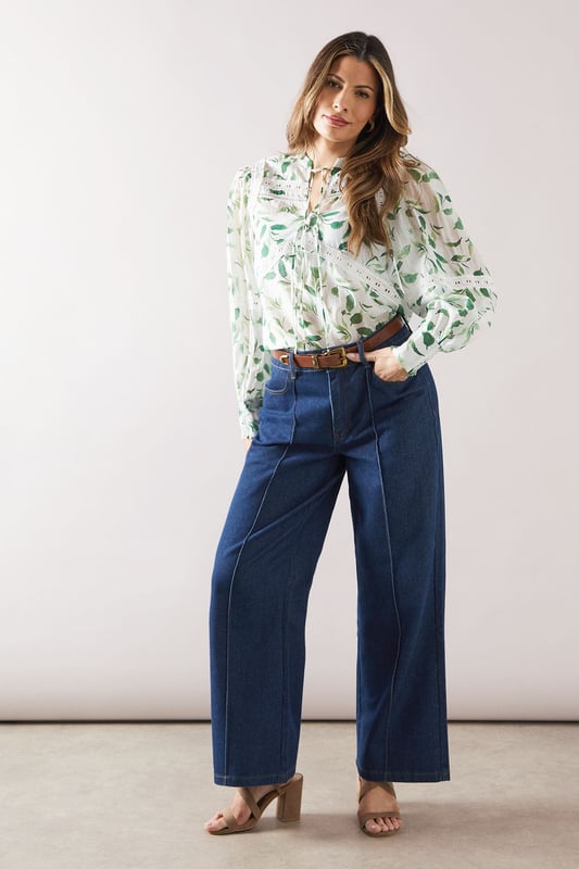Charming floral print blouse with delicate lace inserts
        Elegant crew neckline with tie-front detail
        Long sleeves with gathered cuffs for a feminine touch
        Flattering loose fit for comfort and style
        Versatile design suitable for various daytime occasions
    
    Embrace effortless sophistication with this enchanting floral printed blouse from Wallis. The intricate lace inserts add a touch of romance, while the tie-front detail at the neckline allows for customisable styling. Perfect for those who appreciate comfort without compromising on glamour, this blouse pairs beautifully with wide-leg trousers as shown, or your favourite A-line skirt. Ideal for family gatherings, casual brunches, or a day out shopping, this versatile piece can be dressed up or down with ease. Add a statement belt and some delicate jewellery to complete your look. For a relaxed yet put-together ensemble, team with comfortable flats and a tote bag. This blouse is a wardrobe essential that will have you looking polished and feeling confident for any daytime event.