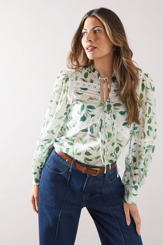 Charming floral print blouse with delicate lace inserts
        Elegant crew neckline with tie-front detail
        Long sleeves with gathered cuffs for a feminine touch
        Flattering loose fit for comfort and style
        Versatile design suitable for various daytime occasions
    
    Embrace effortless sophistication with this enchanting floral printed blouse from Wallis. The intricate lace inserts add a touch of romance, while the tie-front detail at the neckline allows for customisable styling. Perfect for those who appreciate comfort without compromising on glamour, this blouse pairs beautifully with wide-leg trousers as shown, or your favourite A-line skirt. Ideal for family gatherings, casual brunches, or a day out shopping, this versatile piece can be dressed up or down with ease. Add a statement belt and some delicate jewellery to complete your look. For a relaxed yet put-together ensemble, team with comfortable flats and a tote bag. This blouse is a wardrobe essential that will have you looking polished and feeling confident for any daytime event.