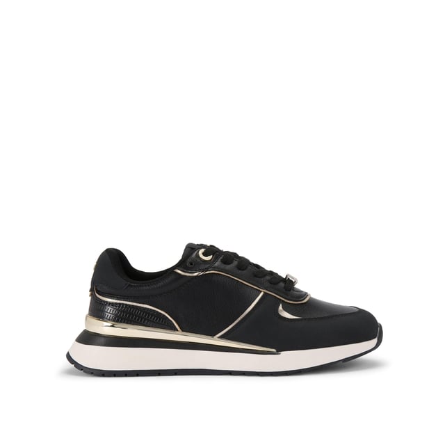 The List is a white sneaker with black and metallic gold panels across the upper. The front laces up with gold tone hardware details.