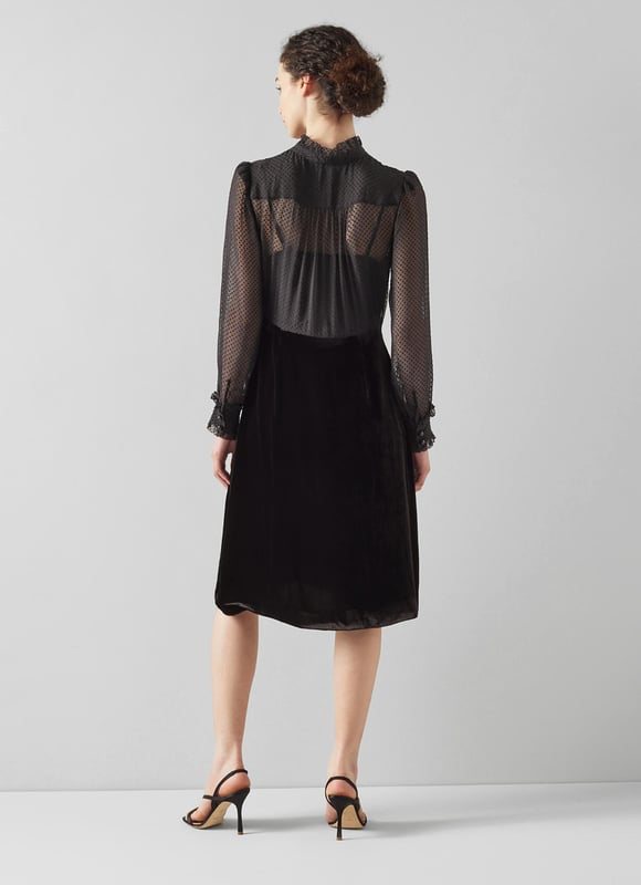 The little black dress is a party season favourite, and our Lucinda velvet dress is perfect for festive occasions. Crafted from soft black velvet, it has a sheer, spotty blouse top with a scallop edge collar, placket and cuffs, tie detail at the neckline and black buttons, and an A-line black velvet skirt. Wear it with strappy heels and a chic clutch.