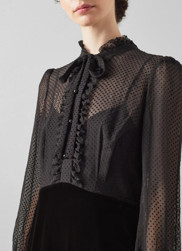 The little black dress is a party season favourite, and our Lucinda velvet dress is perfect for festive occasions. Crafted from soft black velvet, it has a sheer, spotty blouse top with a scallop edge collar, placket and cuffs, tie detail at the neckline and black buttons, and an A-line black velvet skirt. Wear it with strappy heels and a chic clutch.