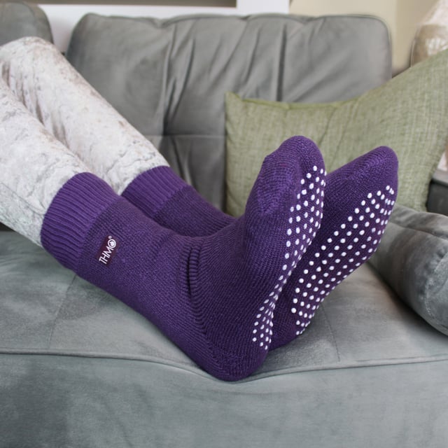 If you're looking for a slipper sock that's going to keep your little one's feet nice and cosy, look no further than THMO Kids Thermal Slipper Socks. The perfect pair to keep them warm while playing indoors. These socks have a stretchy comfort top that moulds to their leg to reduce constriction rings and tightness, which allows for regular circulation. As well as all day comfort, these socks feature a cushioned foot bed providing feet with an extra layer of support. They have been double brushed on the inside to maximise warmth by trapping warm air and keeping it close to their feet and legs. This inner brushing also softens the inside of the sock making it a great choice for keeping them warmer for longer. These anti slip grippers have been designed to prevent you from slipping on surfaces such as hard wooden floors or kitchen tiles. The dotted design on the foot of the sock is simple but effective. Perfect when they’re playing around the house. These Children’s Thermal Socks come in 4 colour options: Black, Navy, Fuchsia, Purple. They also come in 3 kids size options: 9-12 UK, 12-3 UK and 4-5.5 UK, The THMO badge is also heat transferred onto the side of the socks. These socks come in 4 different colours and are made from 93% Acrylic, 6% Polyamide, 1% Elastane. They are available in 3 Children’s sizes 9-12 UK(27-30 EUR 10-1 US), 12-3 UK (30-36 EUR, 13-4 US) and 4-5.5 UK(37-38.5 EUR, 5-6.5 US). They are machine washable at 40.