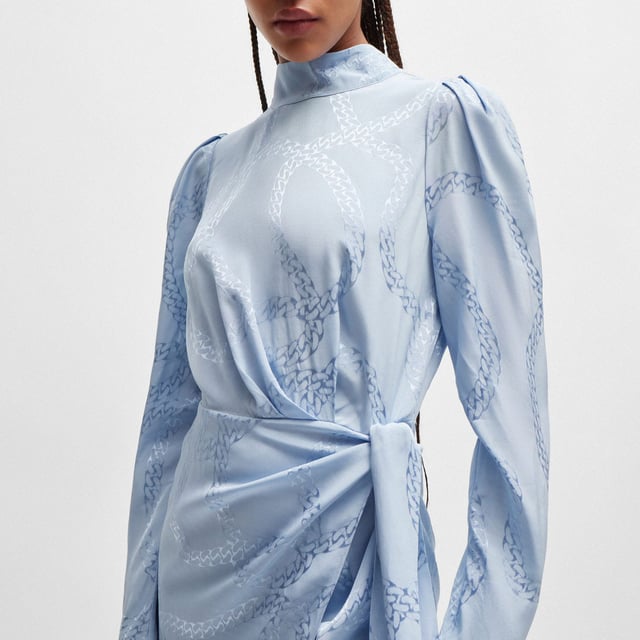 Women's Hugo Boss Kasera Dress. Feminine dress by HUGO Womenswear, crafted in fluent satin material with an all-over chain jacquard, a tie front and gatherings at the shoulders. This product is made with cellulose fibres, derived from natural raw wood material and sourced from responsibly managed forests.- Satin viscose fabric.- Regular fit.- Mock neck.- Long sleeves.- Asymmetric hem with front slit.- All-over chain jacquard pattern.- Unlined. Material: 100% Viscose. Ref: 50515220982.