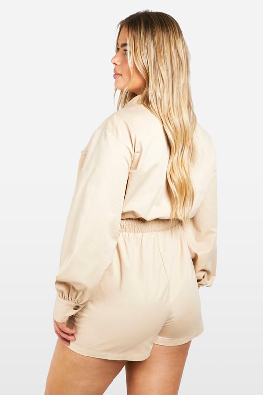 Long-sleeved utility playsuit with collar
        Elasticated waist for a flattering silhouette
        Functional chest pockets for added style and practicality
        Button-up front closure for easy wear
        Relaxed fit shorts for comfort and movement
    
    This versatile utility playsuit is the perfect addition to your going-out wardrobe. The long sleeves and collared neckline add a touch of sophistication, while the elasticated waist creates a flattering shape. Style it with trainers and oversized sunglasses for a cool daytime look, or dress it up with heeled sandals and statement jewellery for a night out with friends. The relaxed fit shorts ensure comfort for dancing the night away, while the functional chest pockets add a practical edge to this trendy piece. Whether you're heading to a bar for drinks or meeting new people at a club, this playsuit will have you looking effortlessly chic and ready for any urban adventure.