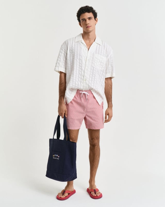  
 Crafted from 100% recycled polyester, these GANT swim shorts are essential for the summer season. Detailed with an all-over seersucker pattern and cut for a regular fit, they have a mid-thigh length and a regular waist. They feature an embroidered GANT shield on the left leg, side seam pockets, a single back pocket, and an elasticated drawstring waistband. This product is made with recycled polyester.

Regular fit
Mid-thigh length
Regular waist
GANT graphic embroidered on left leg

 85% Recycled Polyester, 15% Cotton 

922516001
 