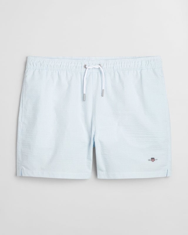  
 Crafted from 100% recycled polyester, these GANT swim shorts are essential for the summer season. Detailed with an all-over seersucker pattern and cut for a regular fit, they have a mid-thigh length and a regular waist. They feature an embroidered GANT shield on the left leg, side seam pockets, a single back pocket, and an elasticated drawstring waistband. This product is made with recycled polyester.

Regular fit
Mid-thigh length
Regular waist
GANT graphic embroidered on left leg

 85% Recycled Polyester, 15% Cotton 

922516001
 