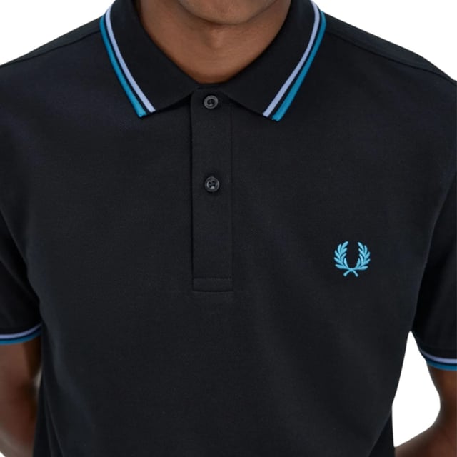The Twin Tipped Fred Perry Polo Shirt by Fred Perry is a short sleeved polo shirt that has been made from Fred Perry's classic cotton piqué, in a contemporary adaptation of Fred's famous streamlined fit. Available in a diverse range of colourways  each with their own unique story. Featuring the signature Fred Perry wreath logo to the chest and twin tipping to the collar and cuffs.