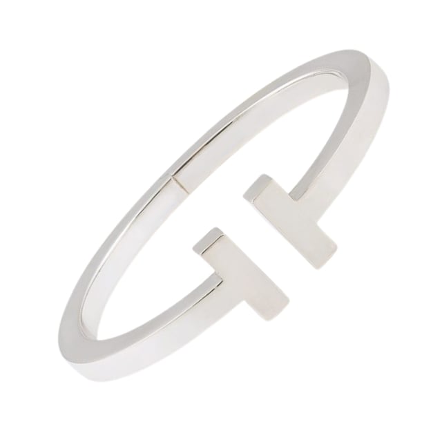 VINTAGE, RRP AS NEW
Square Tiffany T Tiffany & Co Bracelet: Pre-owned Square Tiffany & Co bracelet in 925/1000 silver. An oval bangle opening to a square section (5 x 5 mm) featuring two T's facing each other separated by a space. Signed Tiffany & Co. Condition: Very good condition: this piece of jewelry has been carefully cleaned by a professional jeweler and repackaged in its original Tiffany & Co signed box. Details: . 925/1000 silver. Interior: 5.7 x 4.8 cm
. Exterior: 6.6 x 5.8 cm
. Section: 0.5 cm. Weight: 30.3 gr - Packaging and Certificates: . Original blue cardboard box (Very Good Condition).
. Expertise certificate issued by our partner expert.