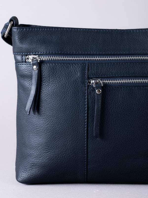 Expertly crafted from premium leather, the Winleigh cross body bag is as practical as it is stylish. Dual front zip pockets elevate this structured silhouette, whilst the adjustable cross body strap allows for versatile and comfortable wear. With plenty of room inside, this classic black bag is ideal for every day. Measurements: 28x24x8