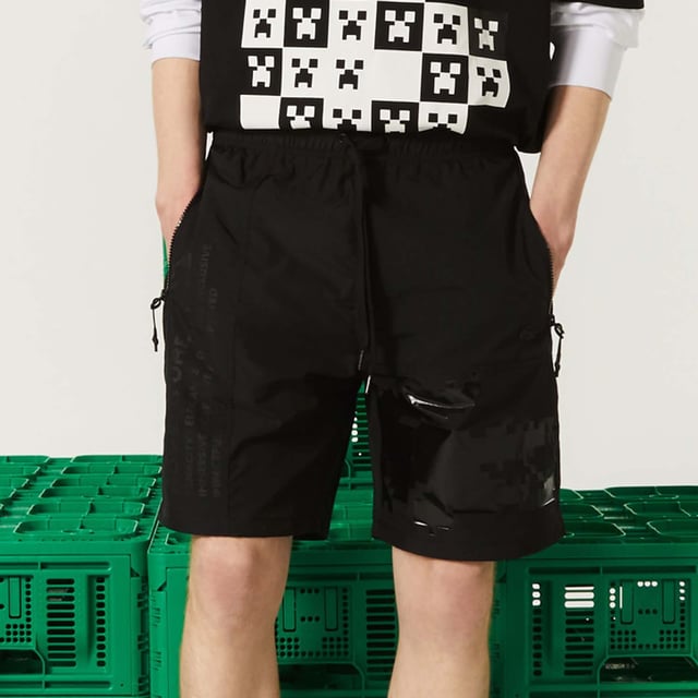 Unisex Lacoste x Minecraft Nylon Bermuda Shorts in Black Unisex Lacoste L!VE x Minecraft Nylon Bermuda Shorts.- Regular fit.- Responsible and water-resistant fabrics.- Four zip pockets, elasticised waistband with branded drawstring.- Matte and shiny Lacoste and Minecraft prints.- Tone-on-tone silicone crocodile on chest. Material: 100% Polyamide. Ref: FH5981031.