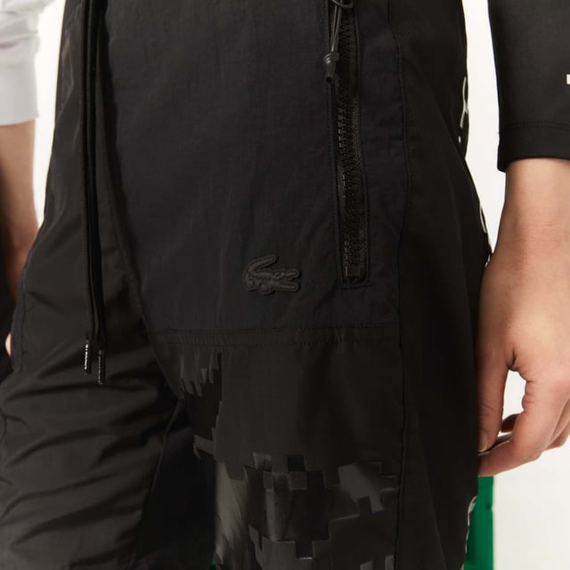 Unisex Lacoste x Minecraft Nylon Bermuda Shorts in Black Unisex Lacoste L!VE x Minecraft Nylon Bermuda Shorts.- Regular fit.- Responsible and water-resistant fabrics.- Four zip pockets, elasticised waistband with branded drawstring.- Matte and shiny Lacoste and Minecraft prints.- Tone-on-tone silicone crocodile on chest. Material: 100% Polyamide. Ref: FH5981031.