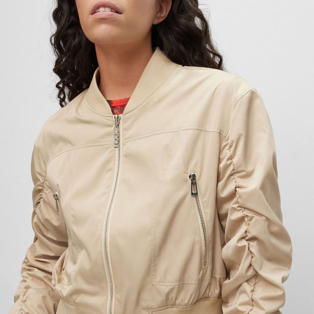 bomber jacket - cropped - round shoulder - zip closure - zip pockets - rib crew neck and rib cuffs - rushing on sleeves - contrast lining - satin - HUGO rivet detail - main material: 100% polyester - lining: 100% polyester - rib: 98% polyester  2% elastane - machine washable.