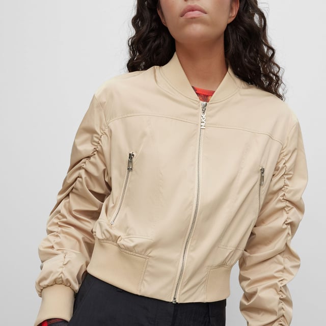 bomber jacket - cropped - round shoulder - zip closure - zip pockets - rib crew neck and rib cuffs - rushing on sleeves - contrast lining - satin - HUGO rivet detail - main material: 100% polyester - lining: 100% polyester - rib: 98% polyester  2% elastane - machine washable.