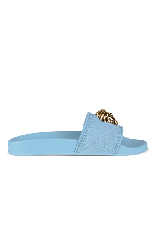 Medusa Versace-slippers van hemelsblauw rubber.Medusa-verfraaide band van goudkleurig metaal met reliëf.Platte rubberen zool.Gemaakt in Italië.